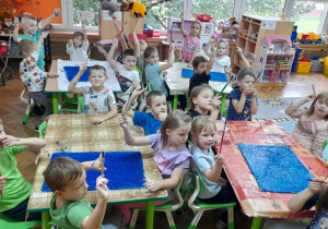 Dzieci przygotowują tło do pracy plastycznej.
