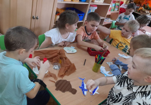 Dzieci przy stolikach pracują nad wybranym zwierzątkiem morskim.