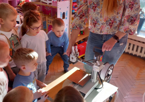 Dzieci oglądają drukarkę 3D.