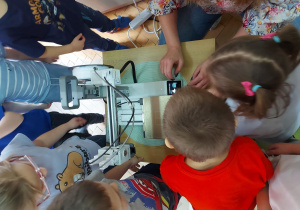 Dzieci poznają zapoznają się z drukarką 3D.