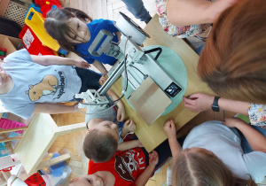 Przedszkolaki obserwują działanie drukarki.