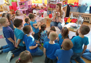 Prowadząca pokazuje zabawkę- statek wydrukowany przez drukarkę 3D.