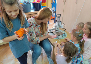 Dziewczynki przyglądają się jak drukarka 3D drukuje kolejną zabawkę.