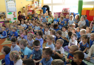 Przedszkolaki słuchają treści przekazywanych przez nauczyciela.