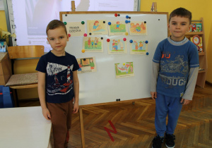 Armin z kolegą pozują przy tablicy do zdjęcia.