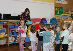 Pani Karolina częstuje dzieci Misiem Lubisiem.