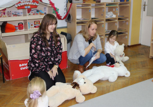 Panie układają misie do snu.