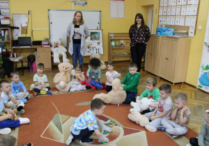 Nikoś podnosi przedmioty w misiowych rękawiczkach.