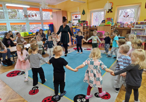 Dzieci wraz z panią Kamilką śpiewają piosenkę w kole