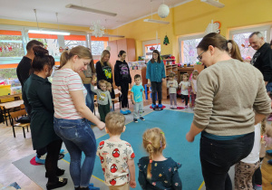 Rodzice wraz z dziećmi wykonują ruchy do zabawy muzycznej