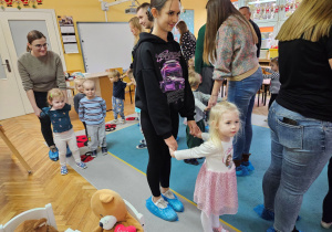 Rodzice z dziećmi w parach poruszają się w rytm muzyki