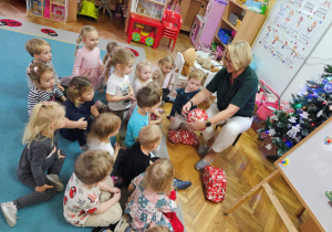 Pani Ania pokazuje dzieciom zapakowane prezenty