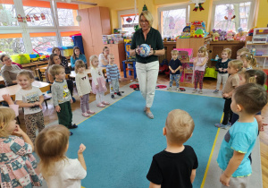 Pani Ania bawi się z dziećmi piłką w kole