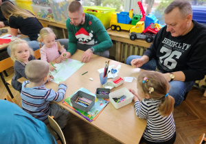 Rodzice wraz z dziećmi w grupie wykonują plakat części trzeciej bajki