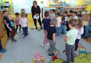 Dzieci słuchają poleceń nauczycielki.