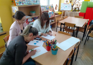 Rodzice rysują propozycje do książeczki.