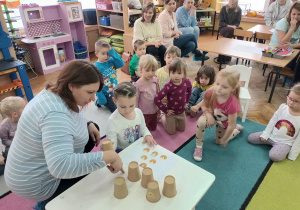 Diana z mamą wykonuje zadanie z kubkami.