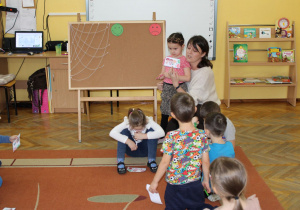 Tosia pokazuje obrazek i opowiada co się na nim dzieje.