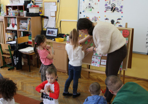 ! Ema z panią Eweliną przypinają pajączka do pajęczyny.