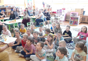 Przedszkolaki z radością słuchają czytanego utworu.