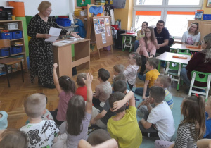 Dzieci zgłaszają się do odpowiedzi na pytania dotyczące wysłuchanej bajki.