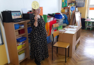 Pani Beata trzyma znaczek przedstawiający smutek i mówi o tym, jak można pomóc osobie, która przeżywa taką emocję.