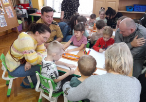 „Misiaczki” wraz z rodzicami przygotowują obrazki do wspólnej książeczki.