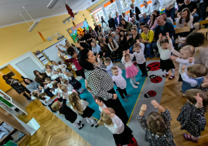 Dzieci z grupy "Biedronek" i "Żabek" wraz z paniami prezentują zabawę muzyczno-ruchową "Trzy kółeczka"