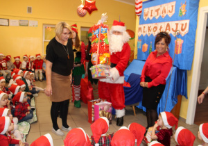 Mikołaj wręcza paczki wychowawczyniom do grupy "Biedronek"