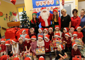 Dzieci z grupy "Biedronek" wraz z Mikołajem, elfami, panią Moniką, panią Kamilką, panią Anią i panią dyrektorpanią