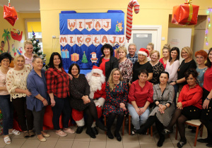 Personel przedszkola oraz pani Dyrektor wraz z Mikołajem i elfami pozują do zdjęcia