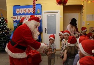 Leoś z grupy "Misiaczków" odbiera prezent od Mikołaja