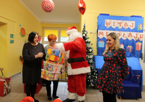 Mikołaj wręcza paczki wychowawczyniom do grupy "Krasnoludki"