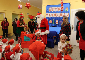 Hela i Marcelinka z grupy "Słoneczka" odbierają prezenty od Mikołaja