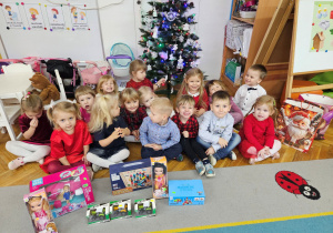 Dzieci z grupy "Biedronki" prezentują nowe zabawki od Mikołaja