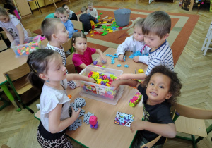 Dzieci z grupy "Żabek" układają przy stoliku budowle z nowych klocków
