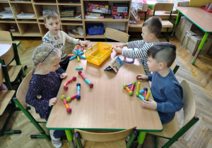 Dzieci z grupy "Żabek" układają przy stoliku budowle z nowych klocków magnetycznych