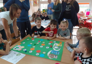 Adaś, Martynka i Lenka pomagają w rysowaniu trasy gry.