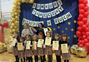 Dziewczynki z dyplomami pozują do zdjęcia.