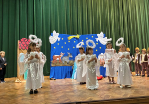 Aniołki tańczą z sercami w dłoniach.