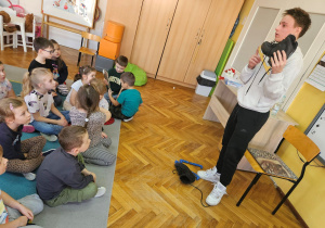 Młody łyżwiarz prezentuje dzieciom łyżwy