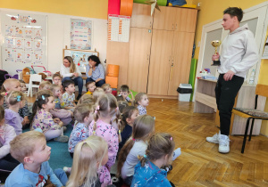 Bartosz prezentuje dzieciom swój puchar za zajęcie I miejsca