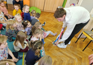 Bartosz pokazuje przedszkolakom swoje medale