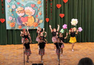 Dziewczynki z koła tanecznego machają rękami do muzyki.