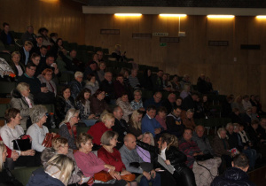 Babcia mówi przez mikrofon tytuł piosenki z muzycznych zagadek.