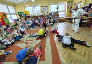 Chłopcy próbują przewrócić na plecy leżących kolegów podczas zabawy ruchowej.
