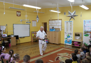 Pan Arek wita się z przedszkolakami i prezentuje swój strój.