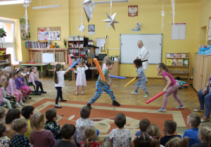 Dzieci pod okiem trenera wykonują ćwiczenia karate.