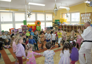 „Słoneczka” naśladują ruchy trenera podczas zabawy ruchowej.