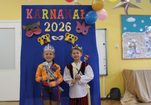 Królewska para na tle karnawałowej ścianki.